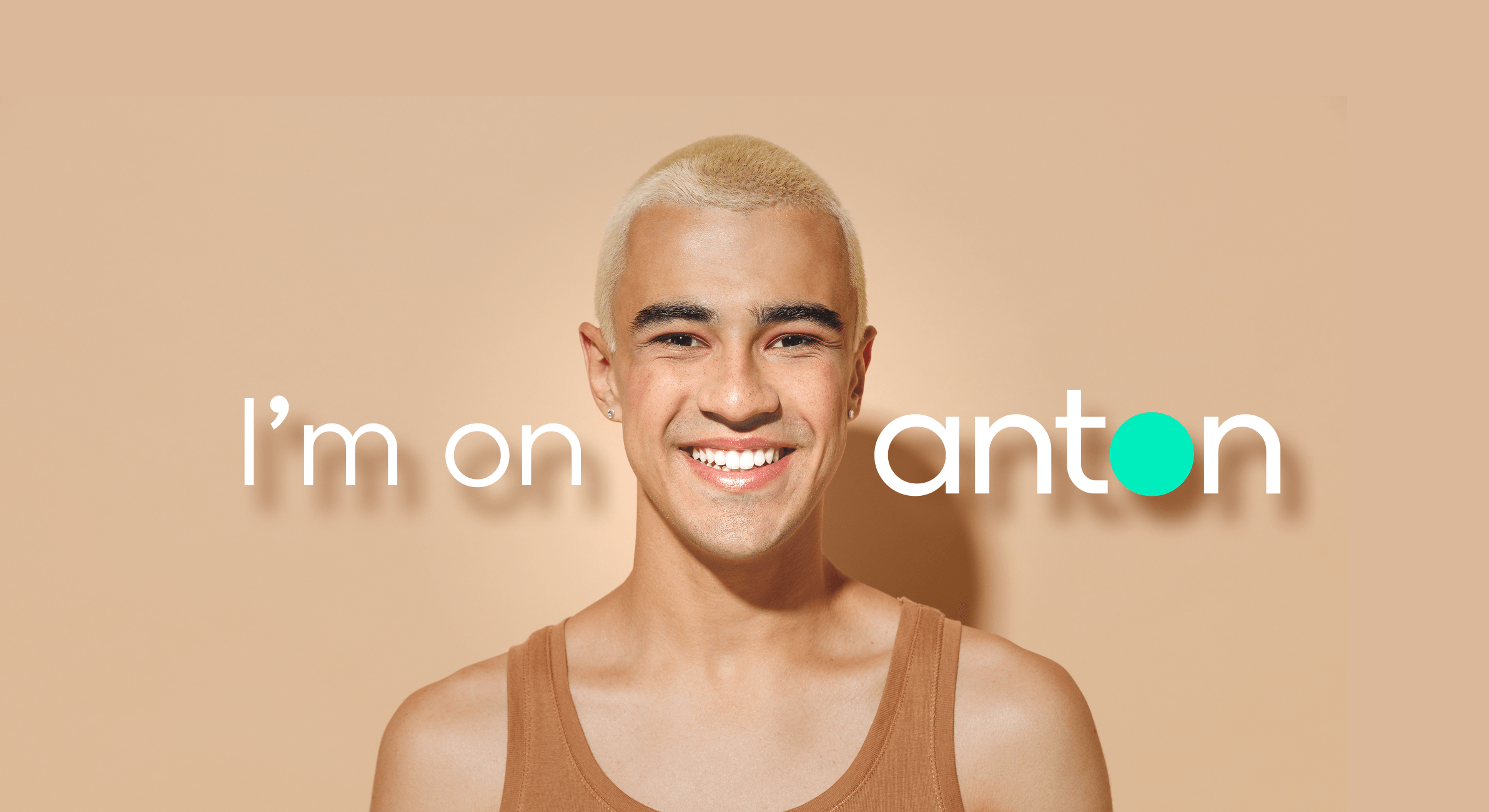 Get on anton — smiling man against a peach background