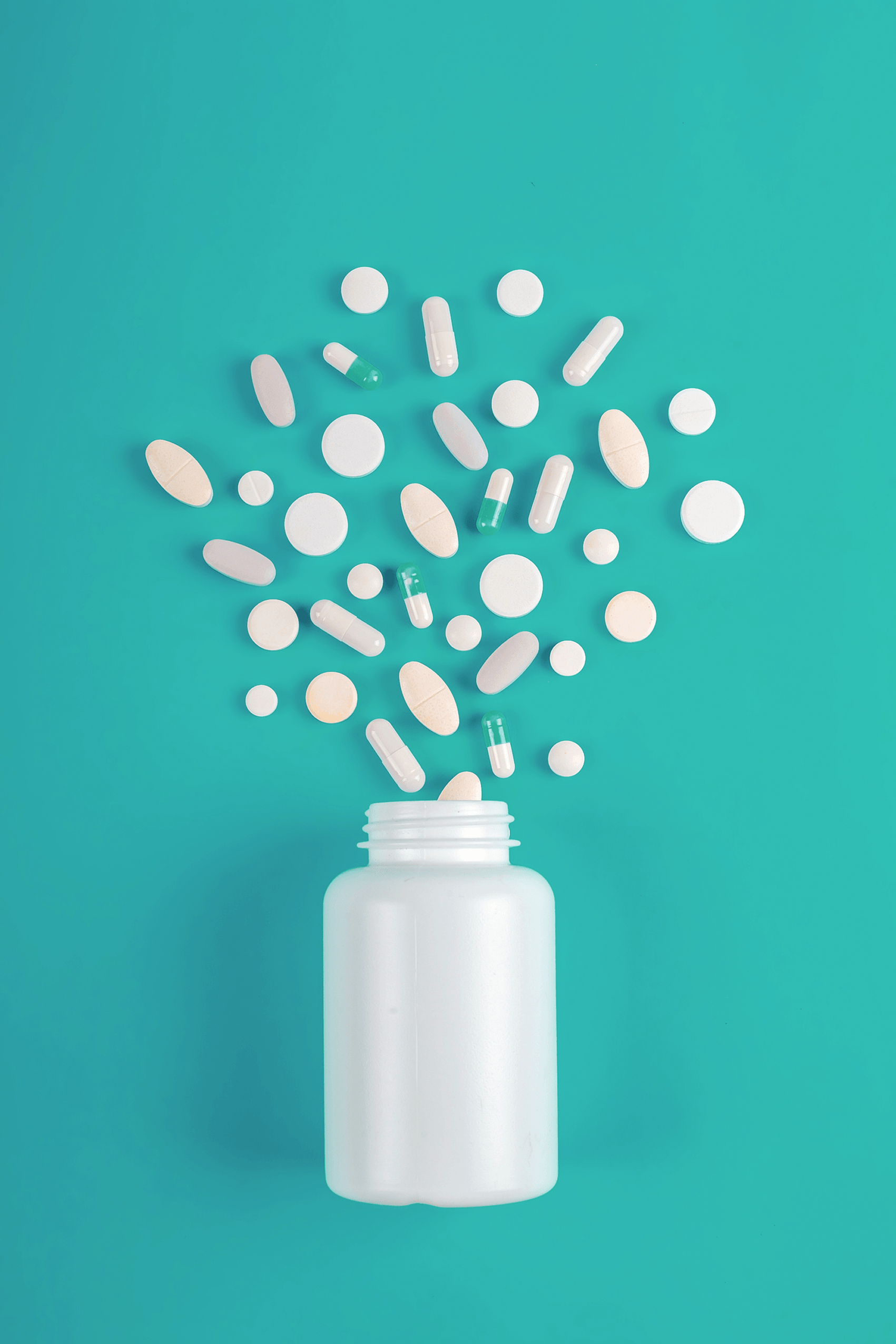 Assorted pills spilling from a bottle