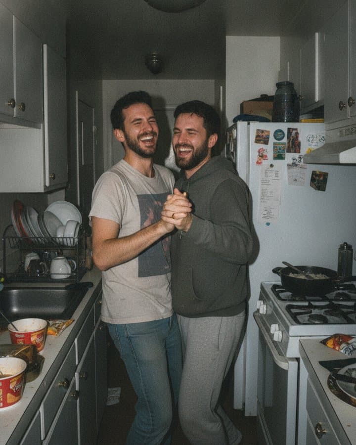 Two men dancing in a small kitchen
